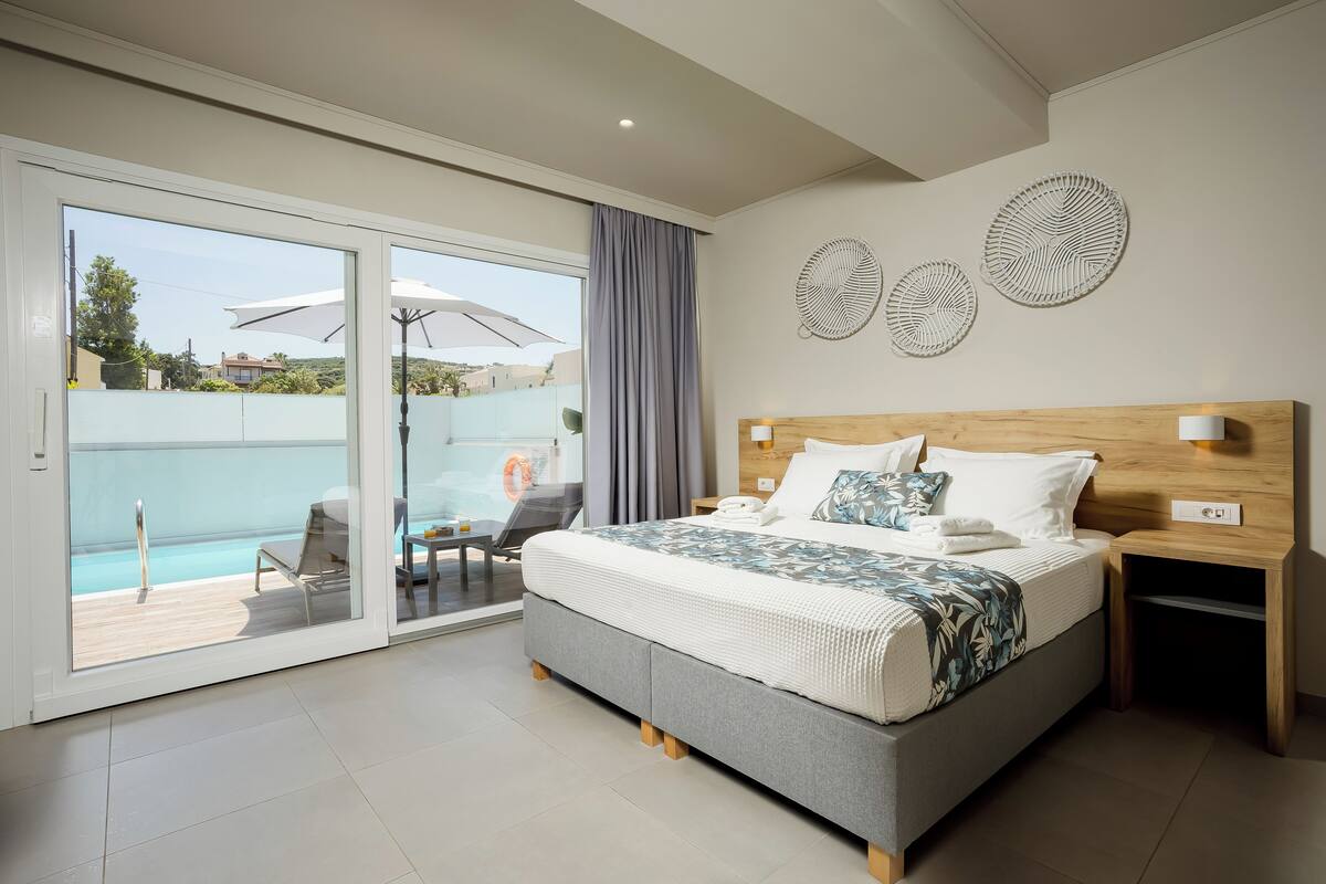 Un dormitorio moderno con una cama grande, un ventanal corredero a un balcón y decoración mural.