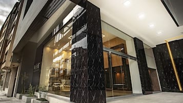 Experience the sleek, contemporary design of our hotel entrance, featuring a striking combination of glass and dark panels.