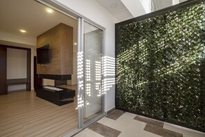 A modern interior with a glass door, a wooden wall, and a wall-mounted light fixture. - Loft Hotel Ipiales (Ipiales)