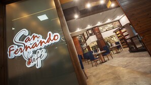 A café interior with a modern design, featuring wooden accents and a glass front. - Loft Hotel Ipiales (Ipiales)