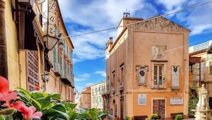 A street with buildings, a fountain, and flowers. - Gaia Apartment with Sea View, 350m from the white beach of Tropea (TROPEA)