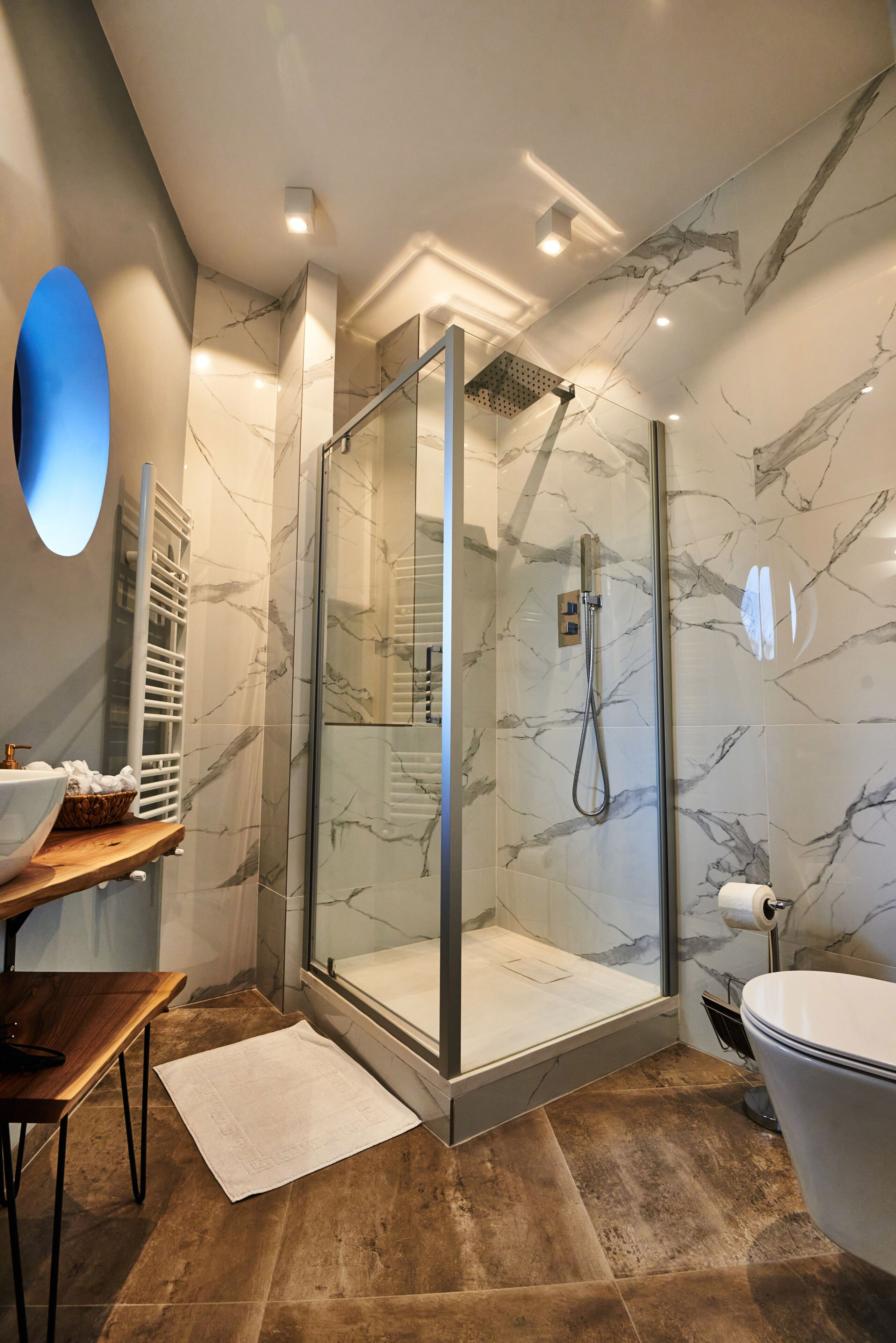 Un bagno moderno con doccia vetrata, un lavabo con piano in marmo e un water.