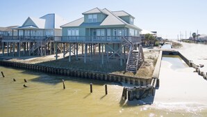 A beachfront house with a wooden deck and a small pool. - Corner pet-friendly, 5/3 bay sunset views! - TraMarLis (Dauphin Island)