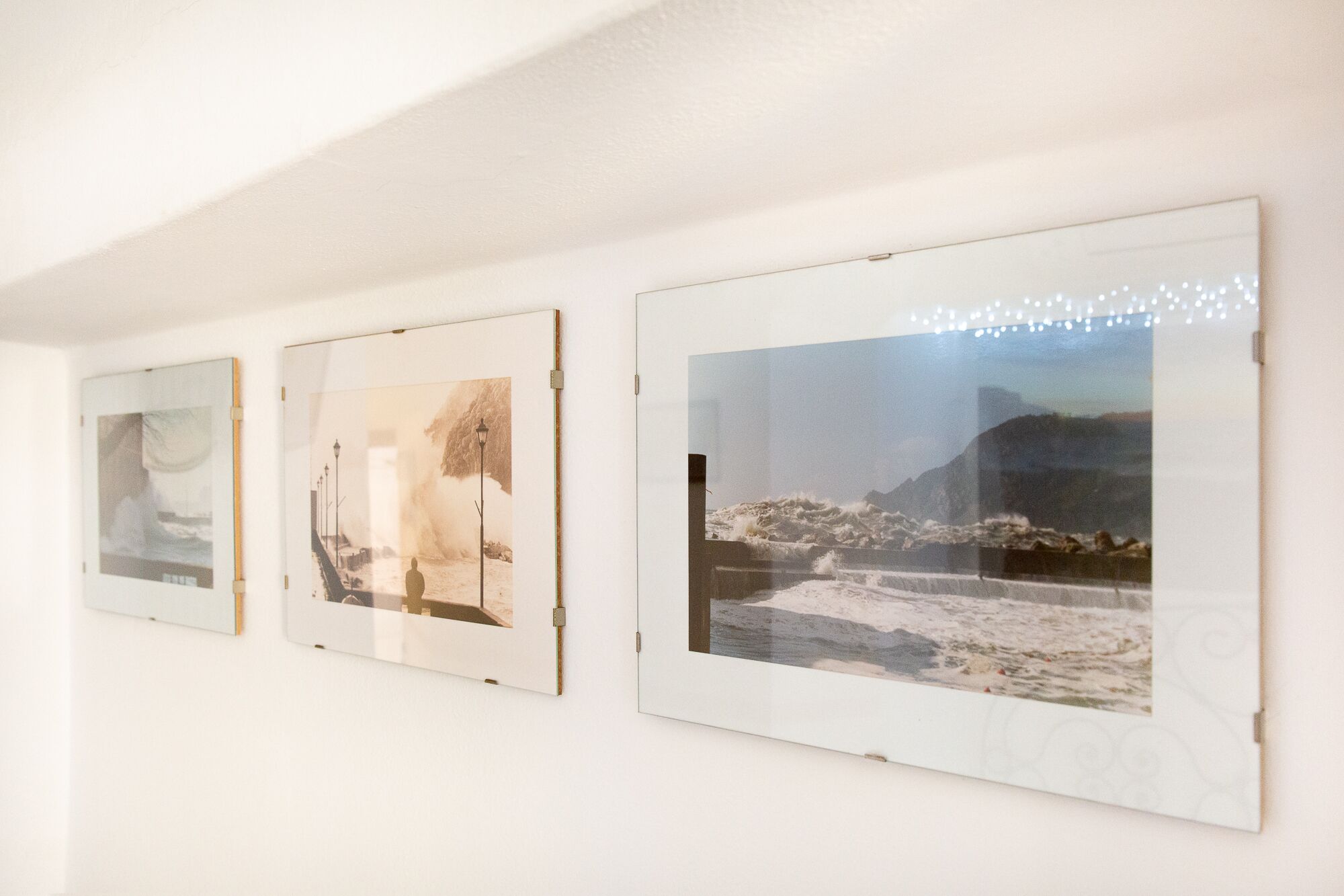 Drei gerahmte Kunstwerke an einer Wand.