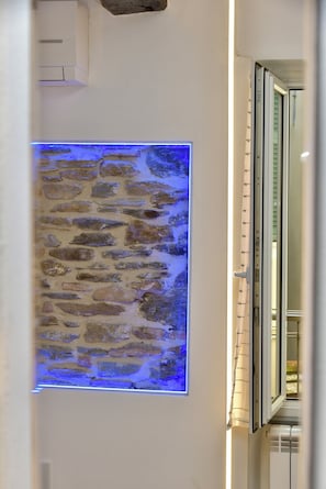Un mur avec un motif texturé qui imite la pierre et une bande lumineuse bleue.