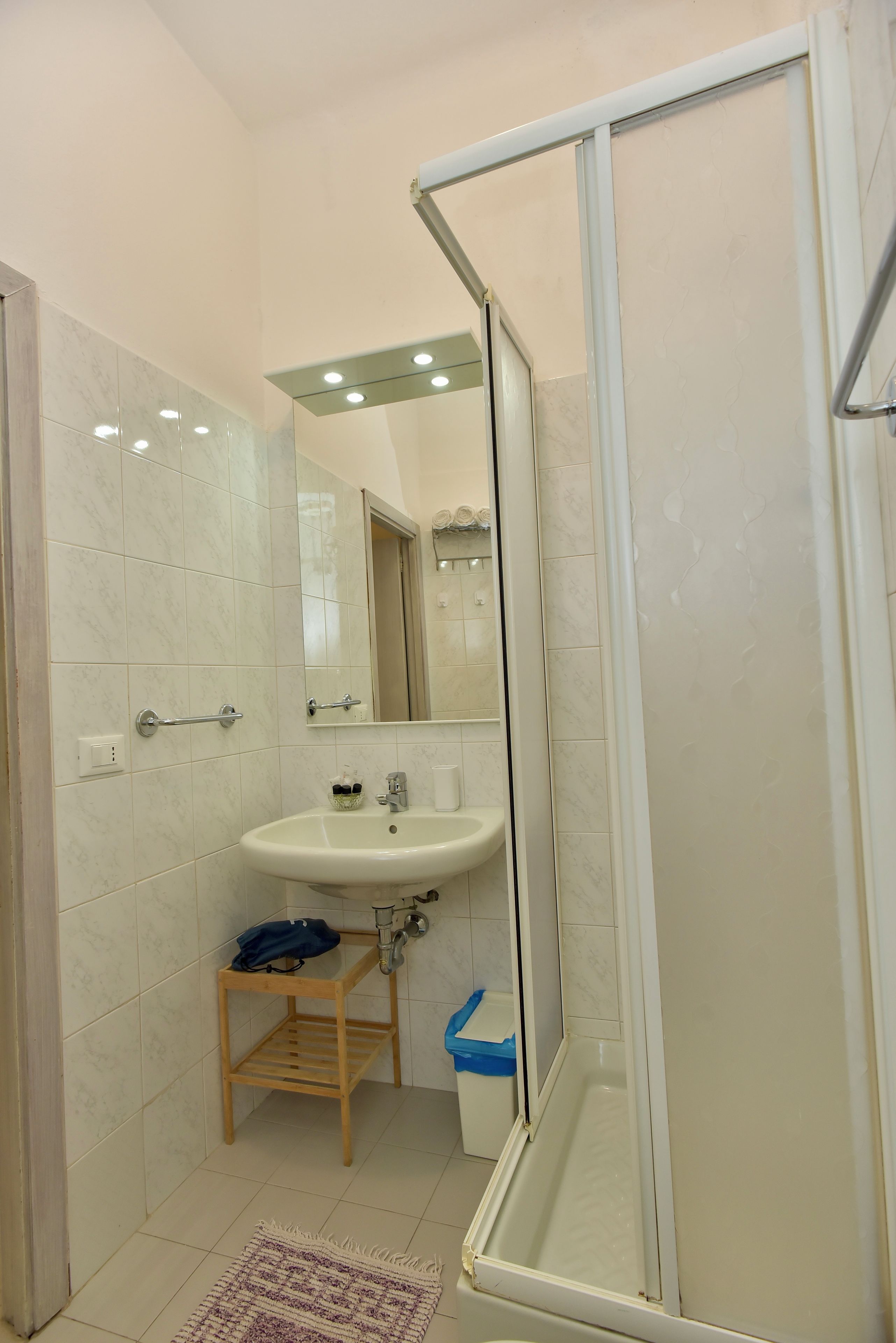 A bathroom with a shower, sink, and a mirror.