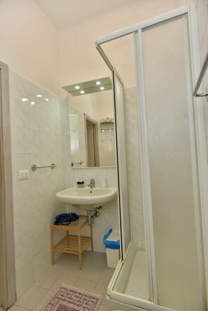 A bathroom with a shower, sink, and a mirror. - Via Del Santo (Vernazza)