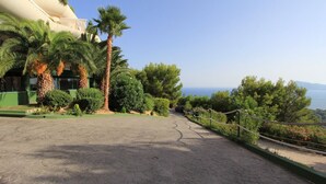 Un chemin pavé mène à un bâtiment d’où l’on a une vue sur la mer.