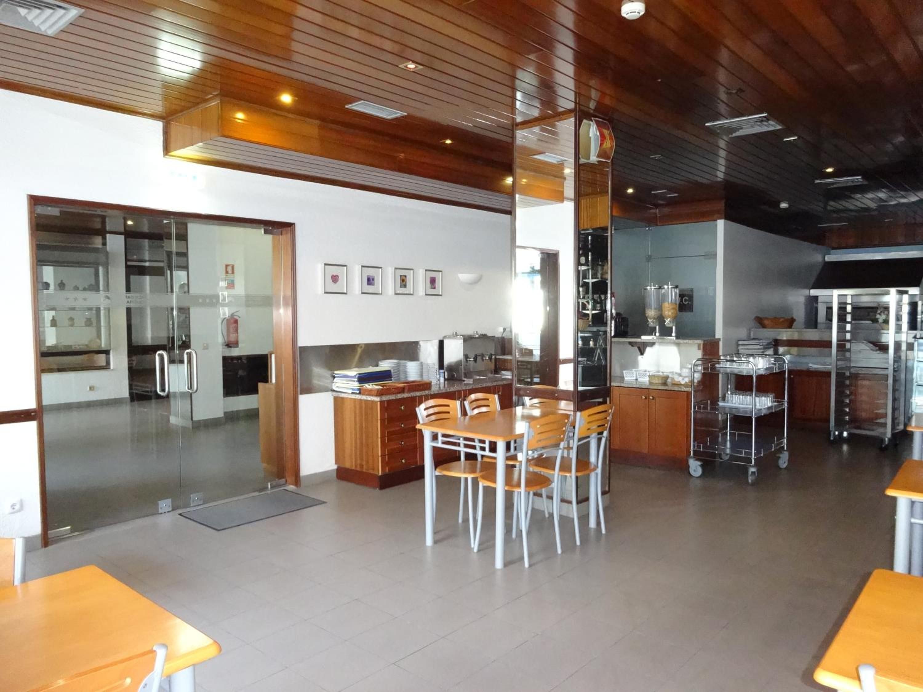 A modern kitchen with stainless steel appliances, wooden cabinets, and a central island with chairs.