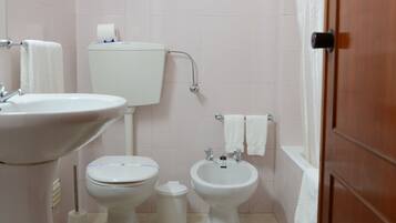 A bathroom with a toilet, bidet, and sink.