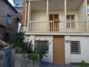 A two-story building with a balcony, a door labeled "Oubelion Room," and a window with blinds.
