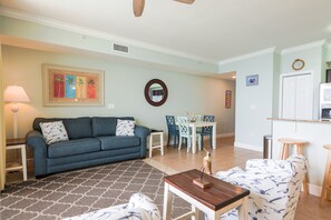 A living room with a blue sofa, a coffee table, and a patterned rug.