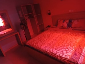 A bedroom with a bed, a wardrobe, and a bedside table. - Jemadex Kings Hotel (Ikorodu)