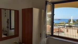 A room with a large window, a mirror, and a wooden wardrobe. - Central apartment with sea view 150 meters from the Bellavista Residence beach (Marina di Camerota)