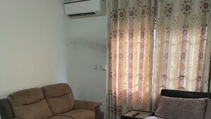 Ein Schlafzimmer mit einem Bett, einem Schlafsofa und einer Klimaanlage an der Wand.
