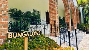 A sign for 'BUNGALOWS' in front of a building with brick arches and a gated entrance. - Club Vergel Resort (Ezequiel Montes)