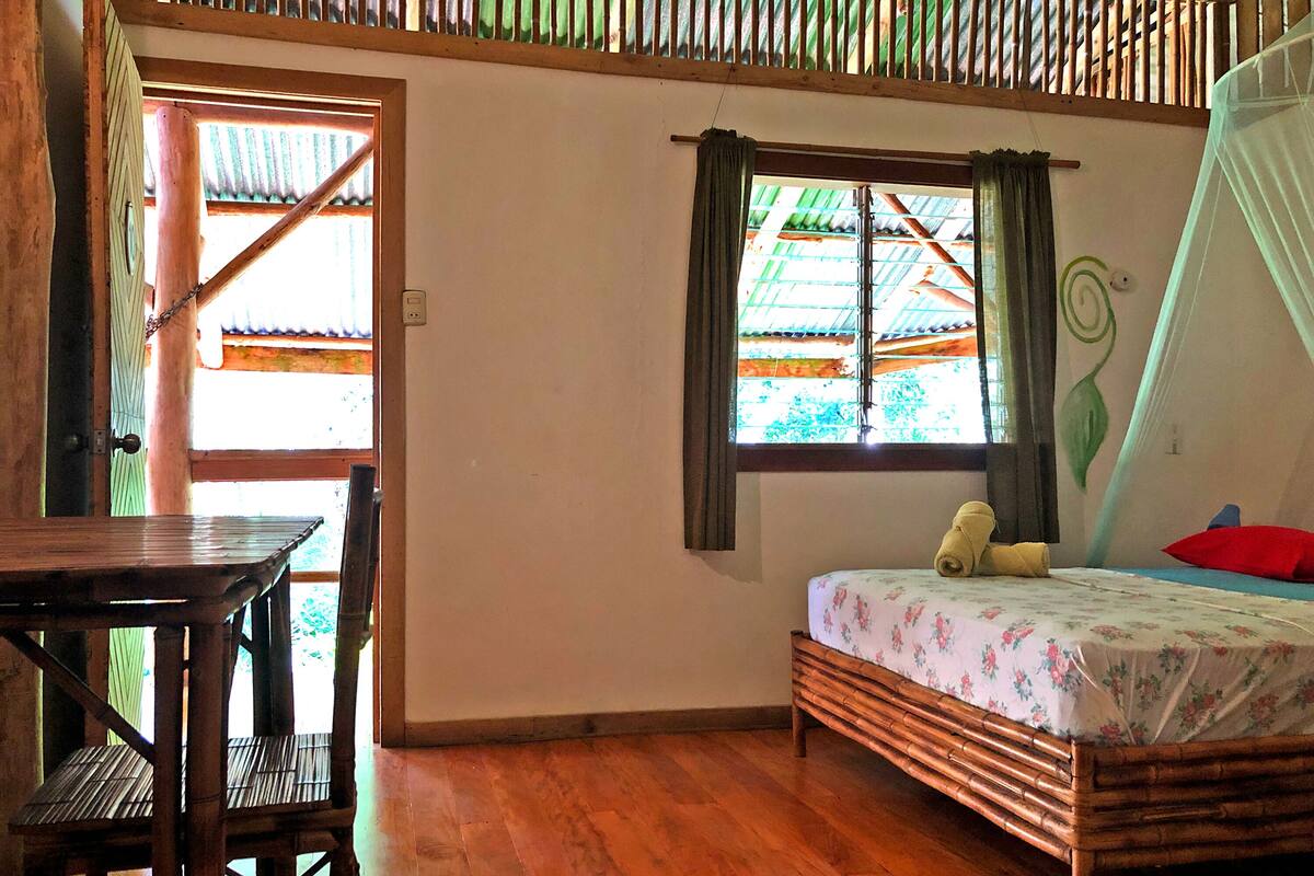 A room with a bed, a table, and a chair.