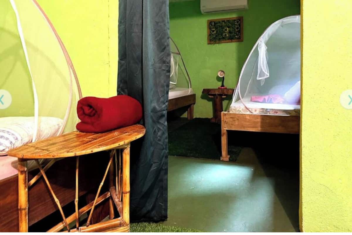A small, compact room with a bed, a wooden table, and a chair.