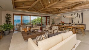 Un amplio salón con techo alto, ventanas grandes y un comedor con vistas.