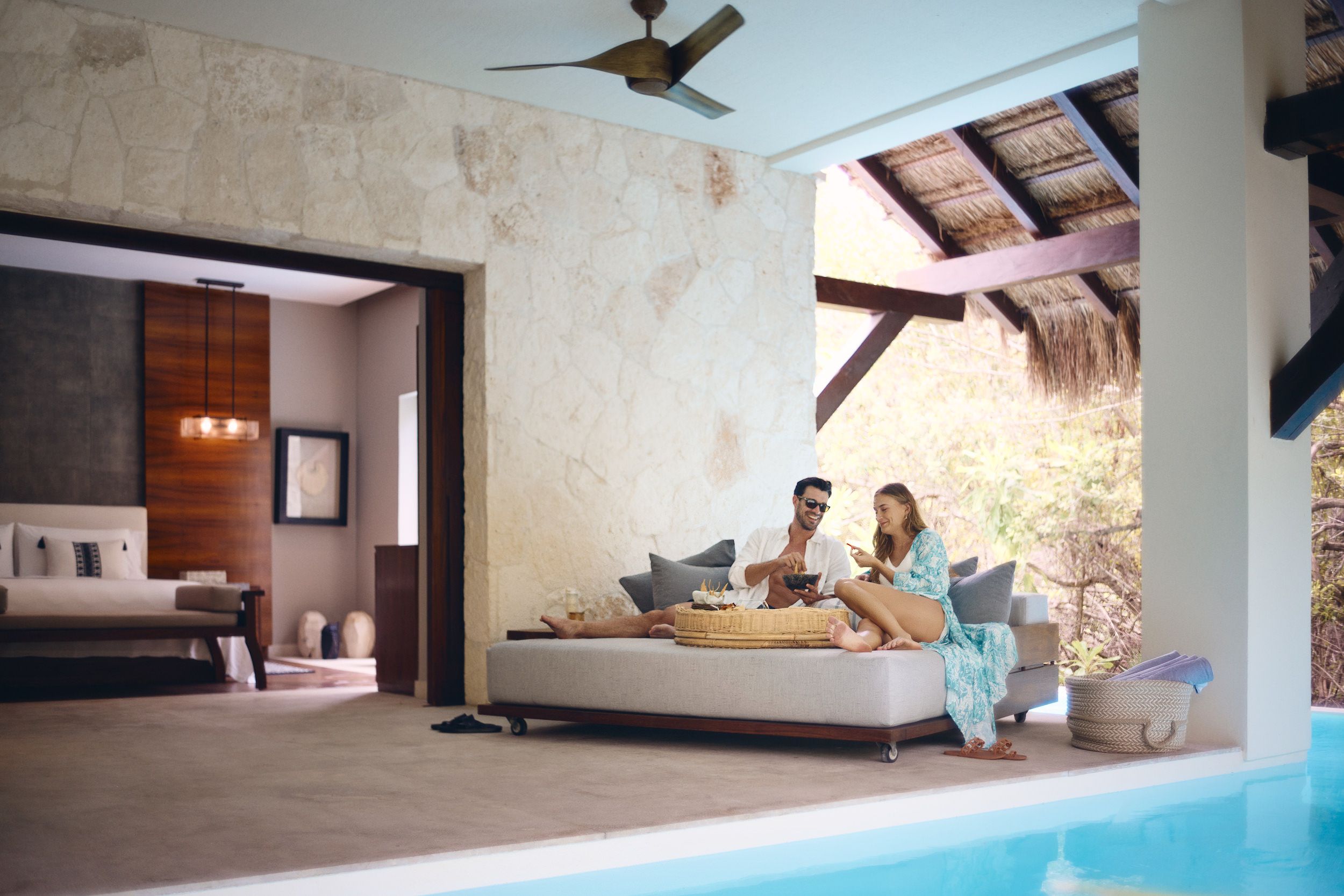 Una sala de estar moderna con un sofá, una mesa de comedor y una piscina.