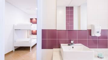 Un baño con un lavamanos blanco, azulejos morados, una bañera blanca y un secamanos blanco.