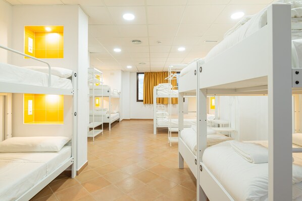 A hotel room with bunk beds, a bathroom with a mirror, and a window with curtains. - Benarrabá Hostel (Benarraba)