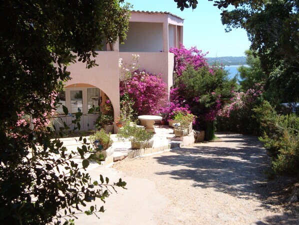 A Mediterranean-style building with a gravel pathway leading to a door.