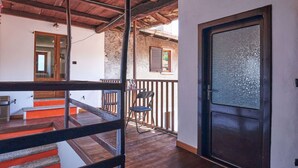 Un escalier en bois menant à un balcon doté d’une porte vitrée.