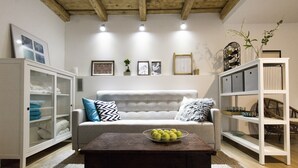 A living room with a sofa, coffee table, and shelving units.