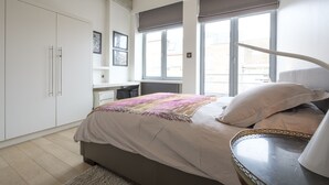 Una camera da letto con un letto, una scrivania e una finestra con persiane.