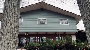 Une maison à deux étages dotée d’un porche et d’un toit à pignon.