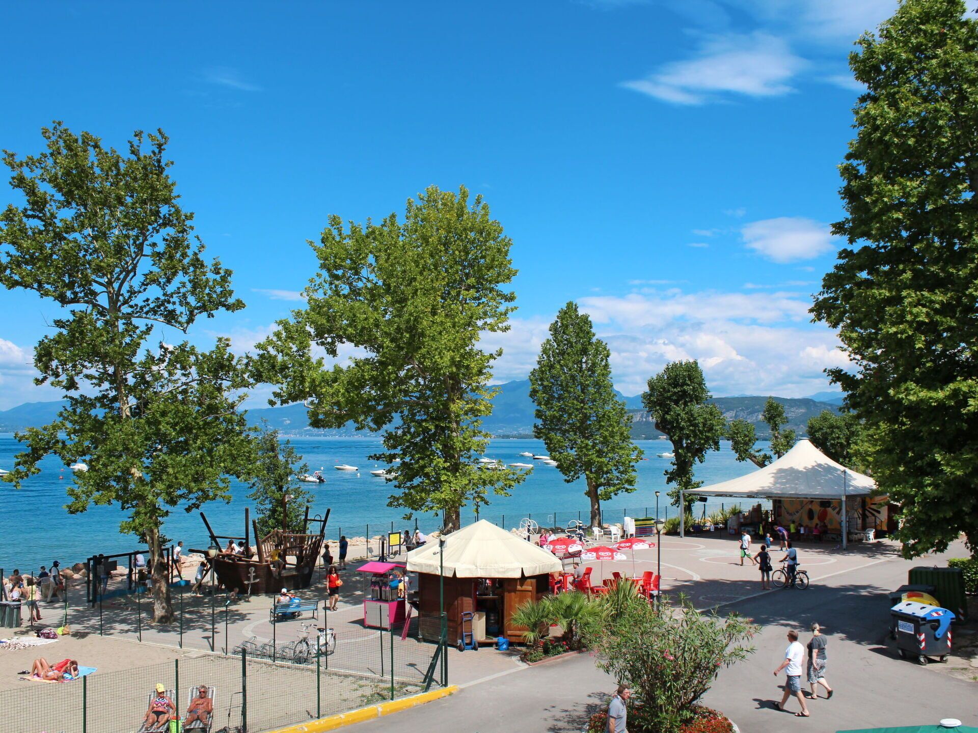 A beachside area with a kiosk, umbrellas, and a view of the sea.