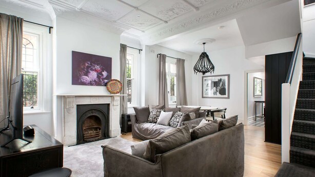 A spacious living room with a fireplace, a sofa set, and a dining area.