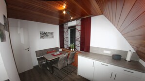 A compact kitchen with a dining area, wooden ceiling, and modern appliances. - Welcome to the Trude house (Wulmeringhausen)