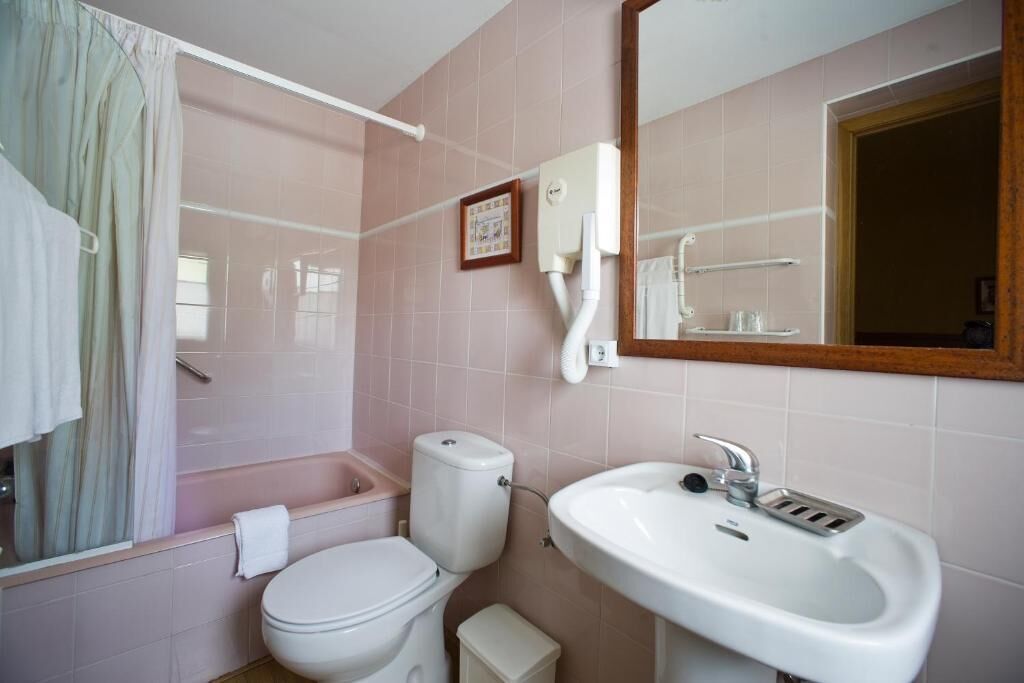 Ein Badezimmer mit Toilette, Waschbecken und Duschvorhang.
