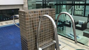 A pool area with a tiled structure and metal railings. - COMPLETE LEISURE COVERAGE  (Praia Grande)