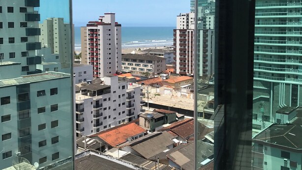 A high-rise building with a view of the beach and other buildings. - COMPLETE LEISURE COVERAGE  (Praia Grande)