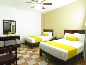 A hotel room with two beds, a desk, and a chair. - Hotel Los Girasoles (Tepic)