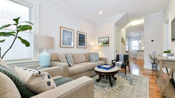 A modern living room with a sofa, coffee table, and artwork on the walls.
