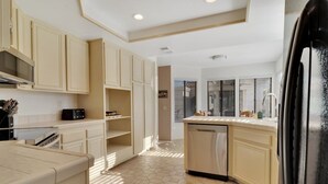 A kitchen with white cabinets, a dishwasher, and a microwave. - Golfer's Paradise | 3BR Santa Rosa Cove (La Quinta)