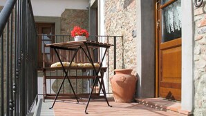 A balcony with a table, chairs, a potted plant, and a large terracotta pot. - Lovely apartment in villa for 6 people with WIFI, pool, TV, patio and pets allowed (Pescia)
