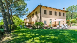A two-story building with a patio area, outdoor seating, and a well-maintained lawn. - Lovely apartment in villa for 4 people with WIFI, pool, TV, patio, pets allowed and panoramic view (Montespertoli)