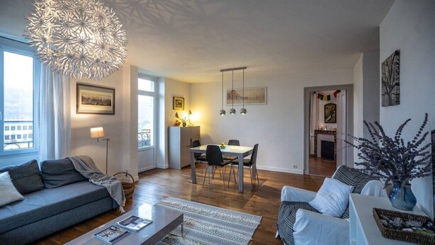 A modern living room with a sofa, coffee table, and dining area. - Bright Airy Spacious Property (Passy)