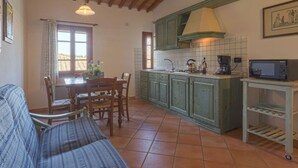 Uma cozinha aconchegante com armários de madeira, painel de azulejos e um espaço de jantar com mesa e cadeiras.