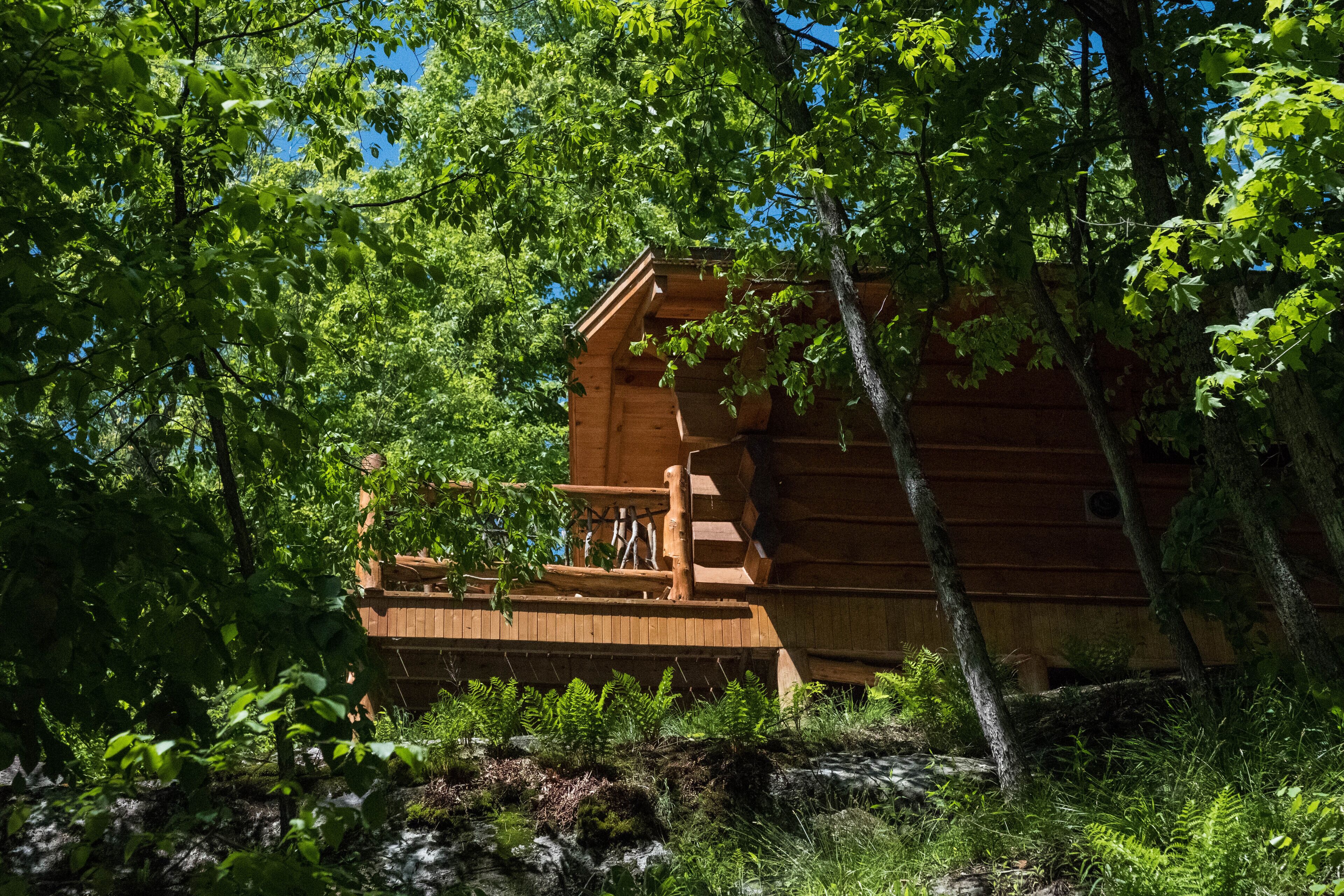 Eine Holzhütte mit einer Holzterrasse und einer Treppe, die zu einem Fenster führt.
