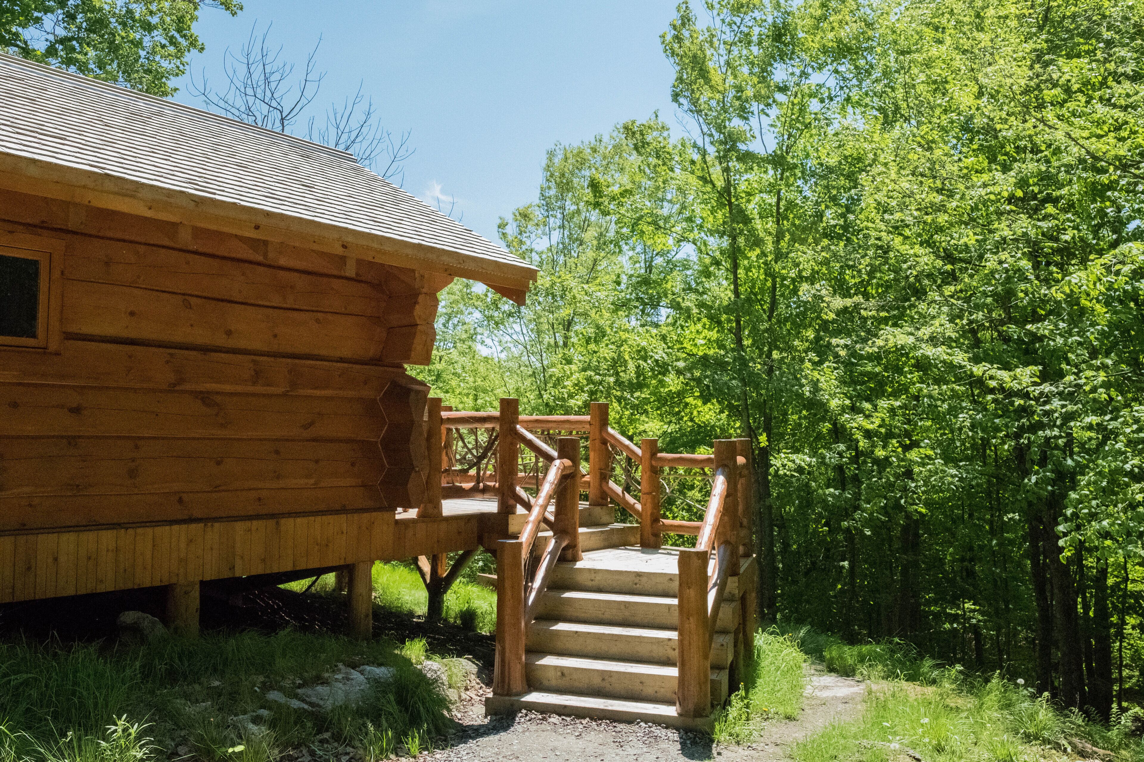 Une cabane en bois avec un escalier en bois menant à une terrasse.