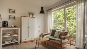 A cozy living room with a sofa, a coffee table, and a cabinet. - Vacation apartment CramerTwo rooms for 4 persons (Gerolzhofen)