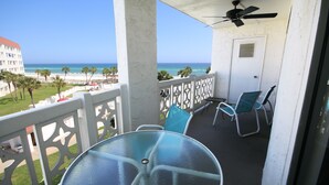 A balcony with a glass table and chairs, a ceiling fan, and a view of the beach and ocean. - El Matador 444 -  FREE TICKETS!! Your stay includes free tickets to many area attractions! (Fort Walton Beach)