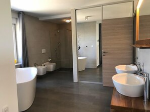 Enjoy a spacious bathroom with a bathtub, double vanity, and separate shower area.
