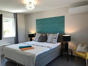 Relax in a spacious room with a large bed, two bedside tables, and a comfortable armchair.